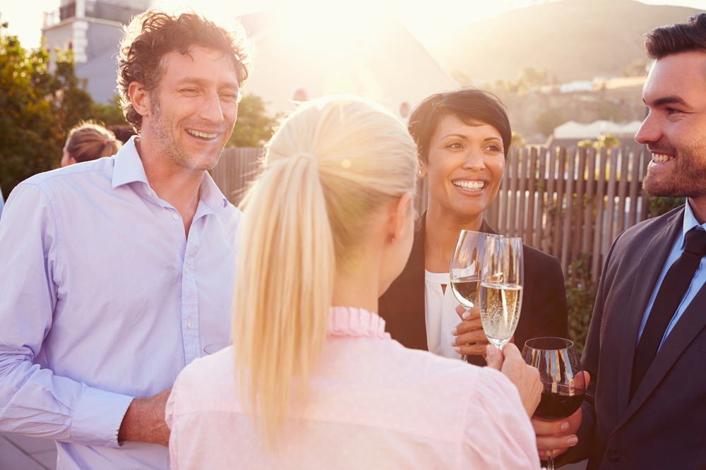 Colleagues drinking after work at a rooftop bar