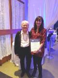 Member of the board of directors, Vera Osidacz (left) and Teapot general director, Carolyn Arsenault, stand with a plaque presented by the mayor of Lachine commemoration the anniversary of the organisation.