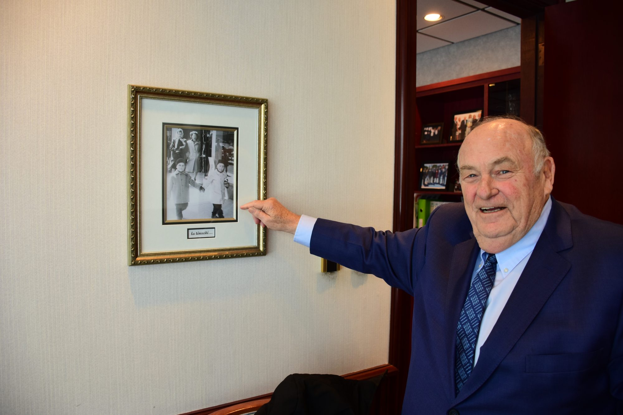 Michel Bissonnet devant une photo encadrée de lui.