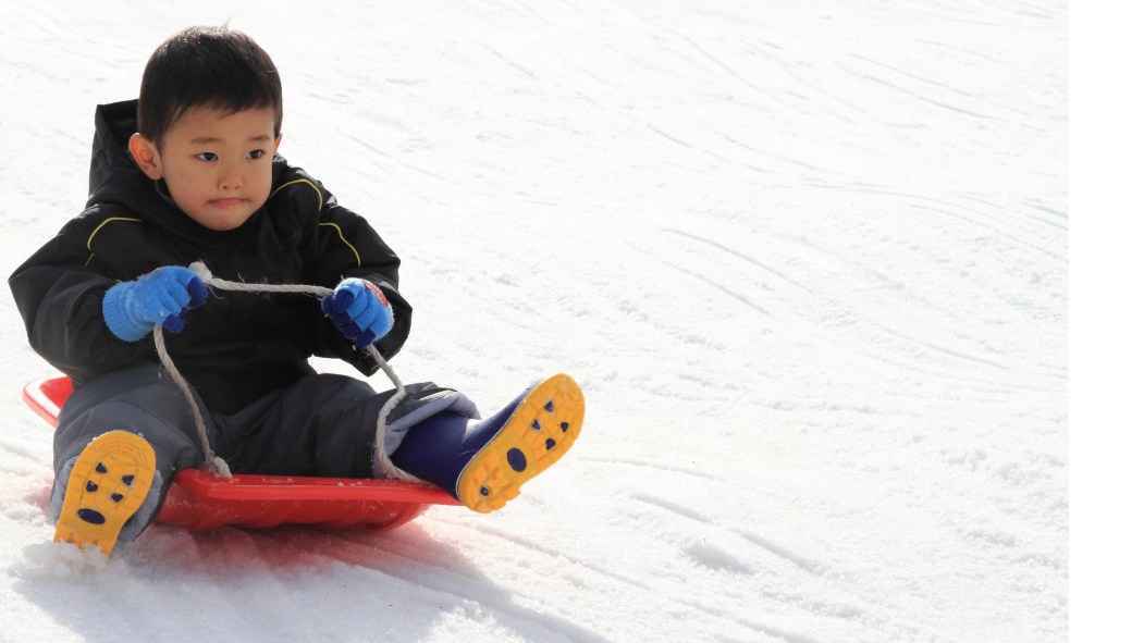 Enfant glissant sur une pente enneigée