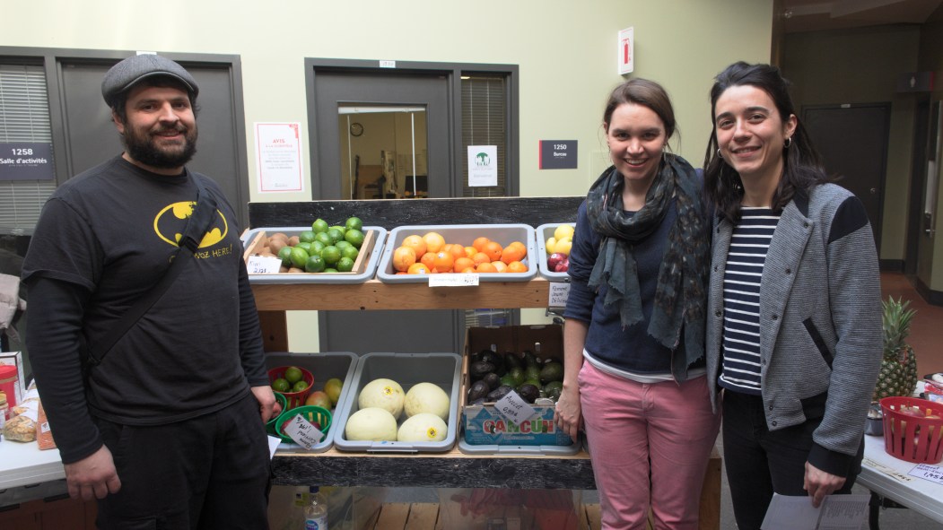 Les organisateurs du marché solidaire devant des étals de fruits et légumes.