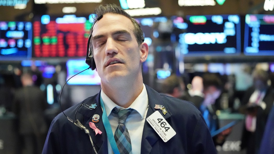 Un homme ferme les yeux devant la chute des indices boursiers à Wallstreet, après une panique due au coronavirus.