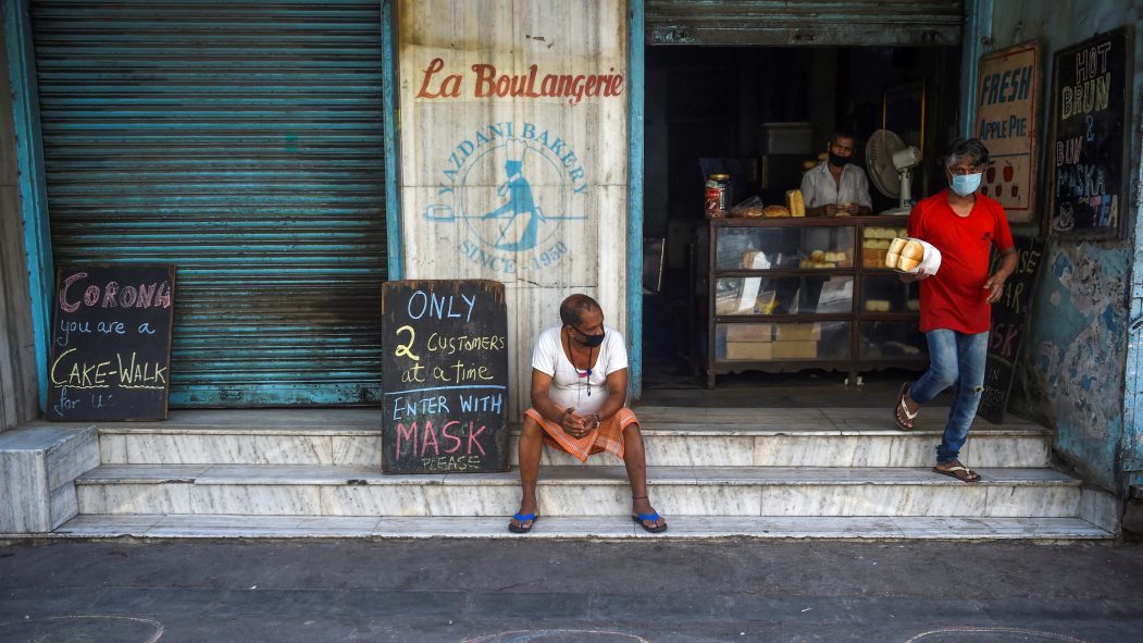 Deux hommes portent des masques contre le coronavirus devant une boulangerie de Mumbai, en Inde.