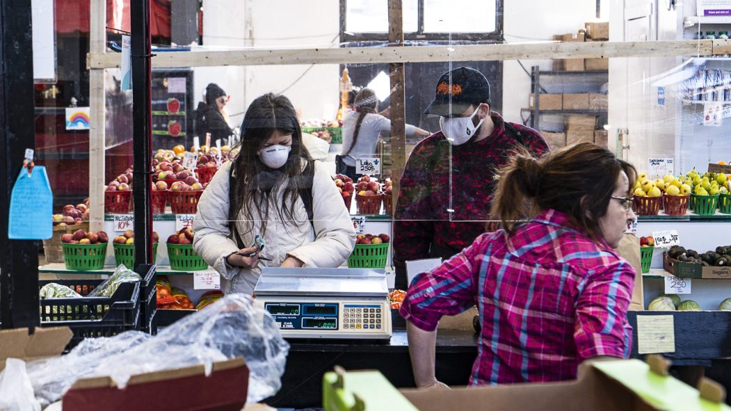 Les étals de fruits et légumes du Marché Jean-Talon protégés par des panneaux de plastique.