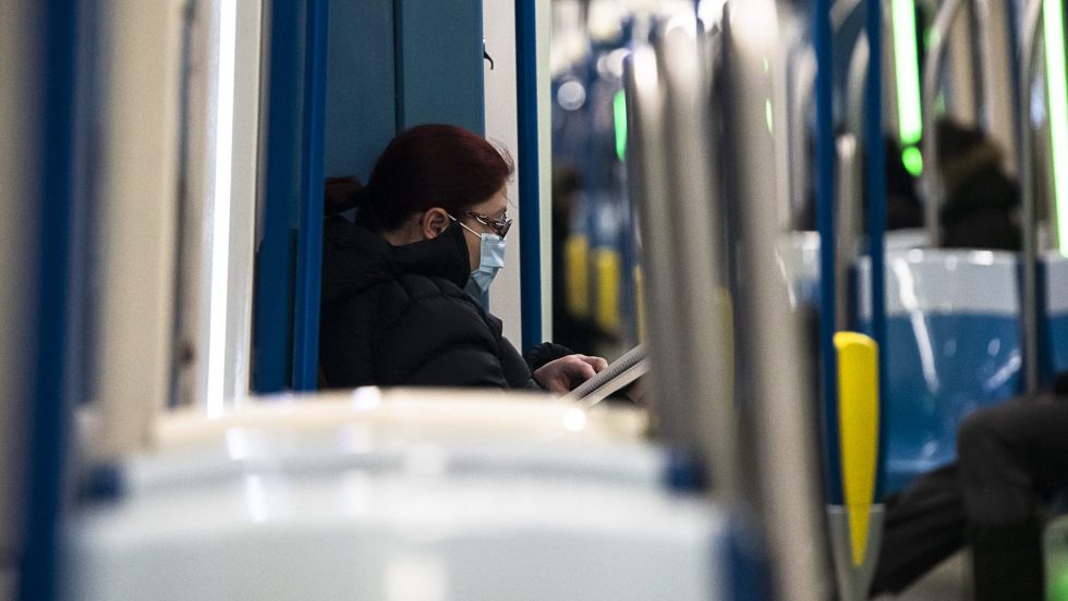 Une femme porte un masque médical dans le métro.