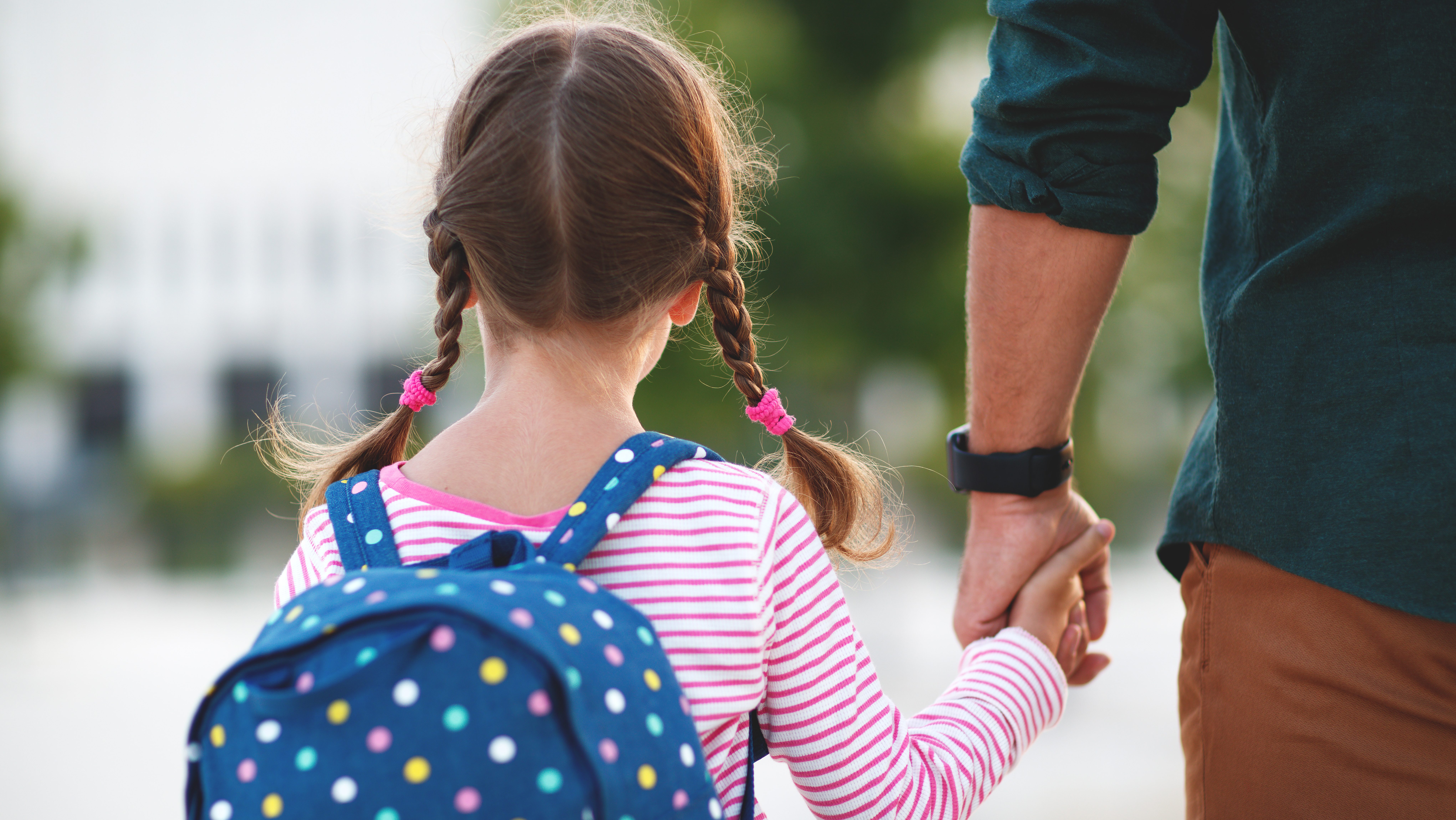 enfant féminin se promenant main dans la main avec un adulte masculin