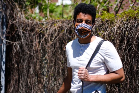 Ismaël Seck avec son vélo et un sac contenant des ordinateurs.