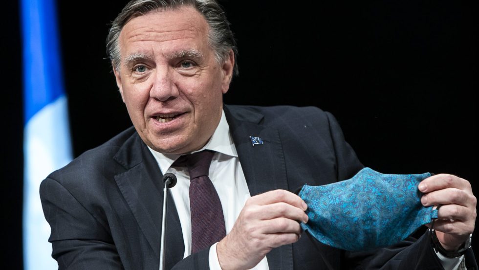 François Legault tient un masque bleu pendant un point de presse portant sur le coronavirus