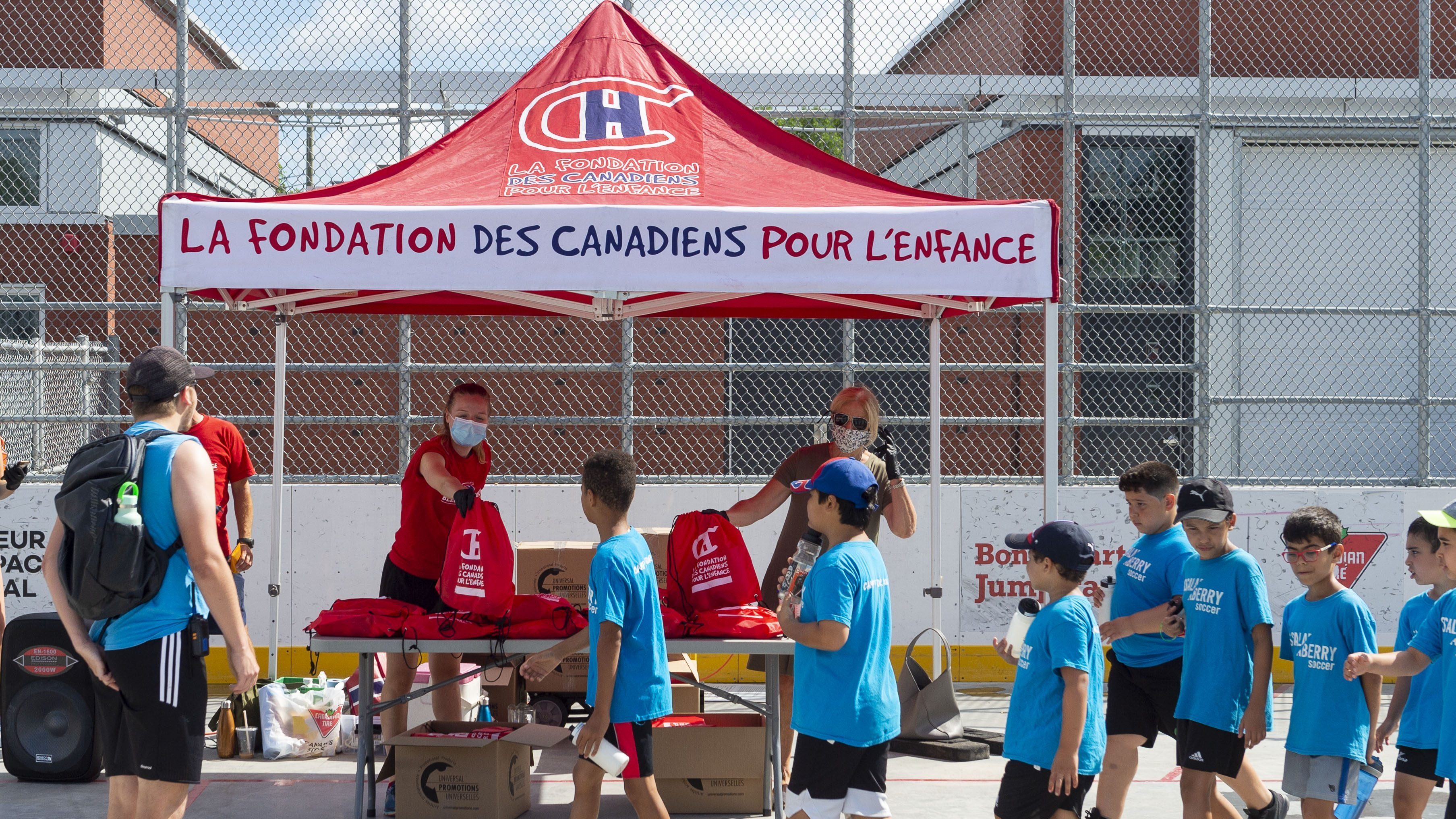 Des jeunes attendent en ligne avant de recevoir leur trousse.