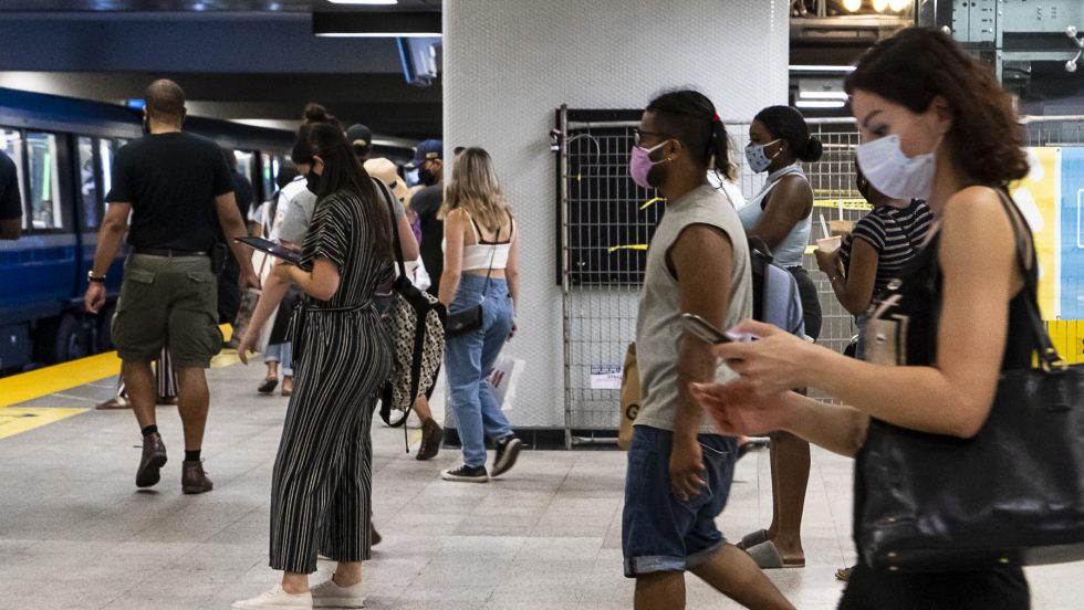 Des personnes portant un masque dans le métro de Montréal.