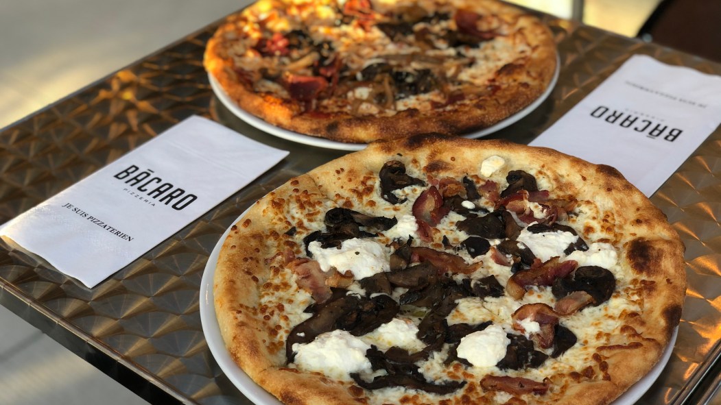 Deux pizzas déposées sur une tables