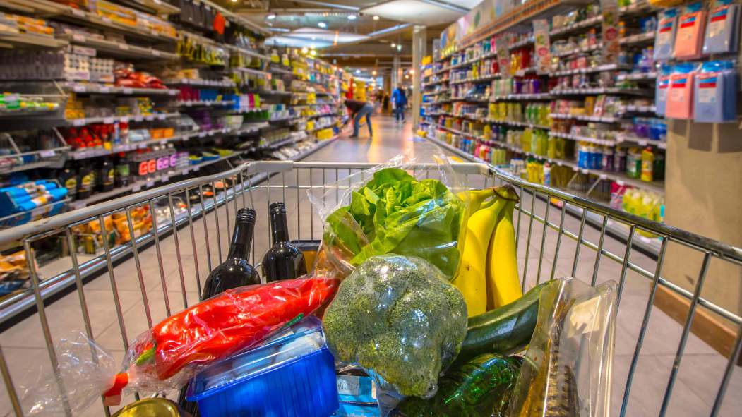 Vu derrière un panier d'épicerie dans une allée de supermarché