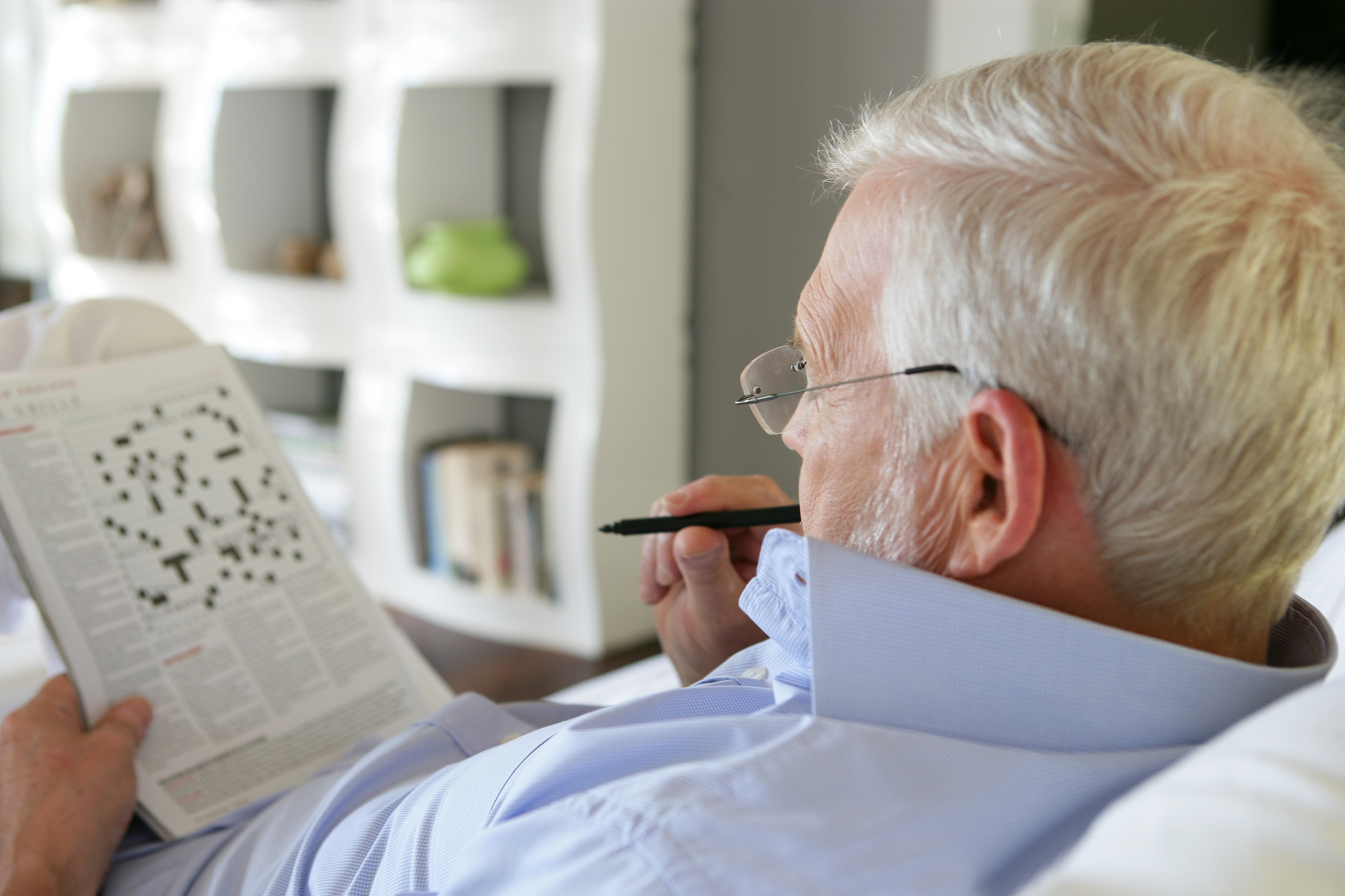 senior man doing crossword