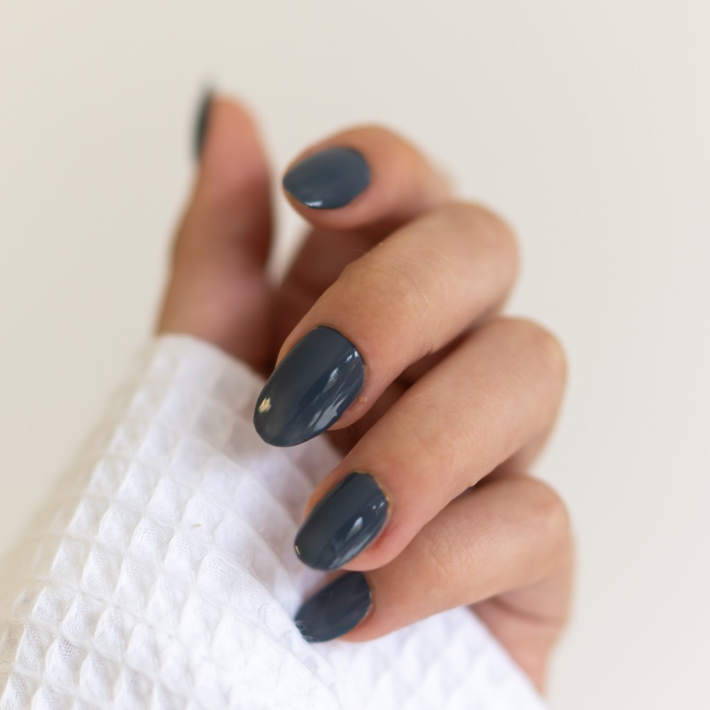 Main affichant une manucure de couleur bleue
