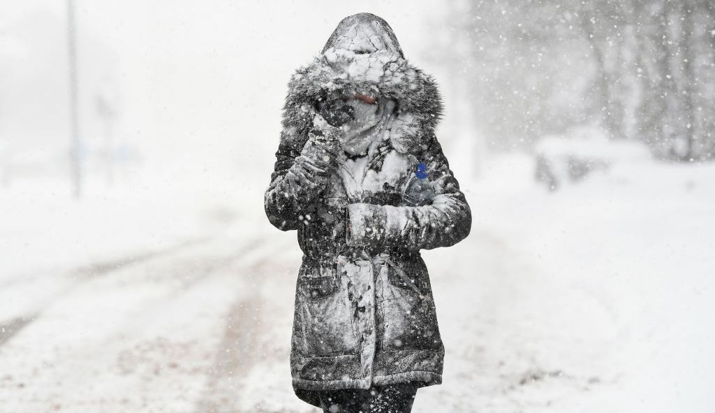 Une jeune femme marche au coeur de l'hiver