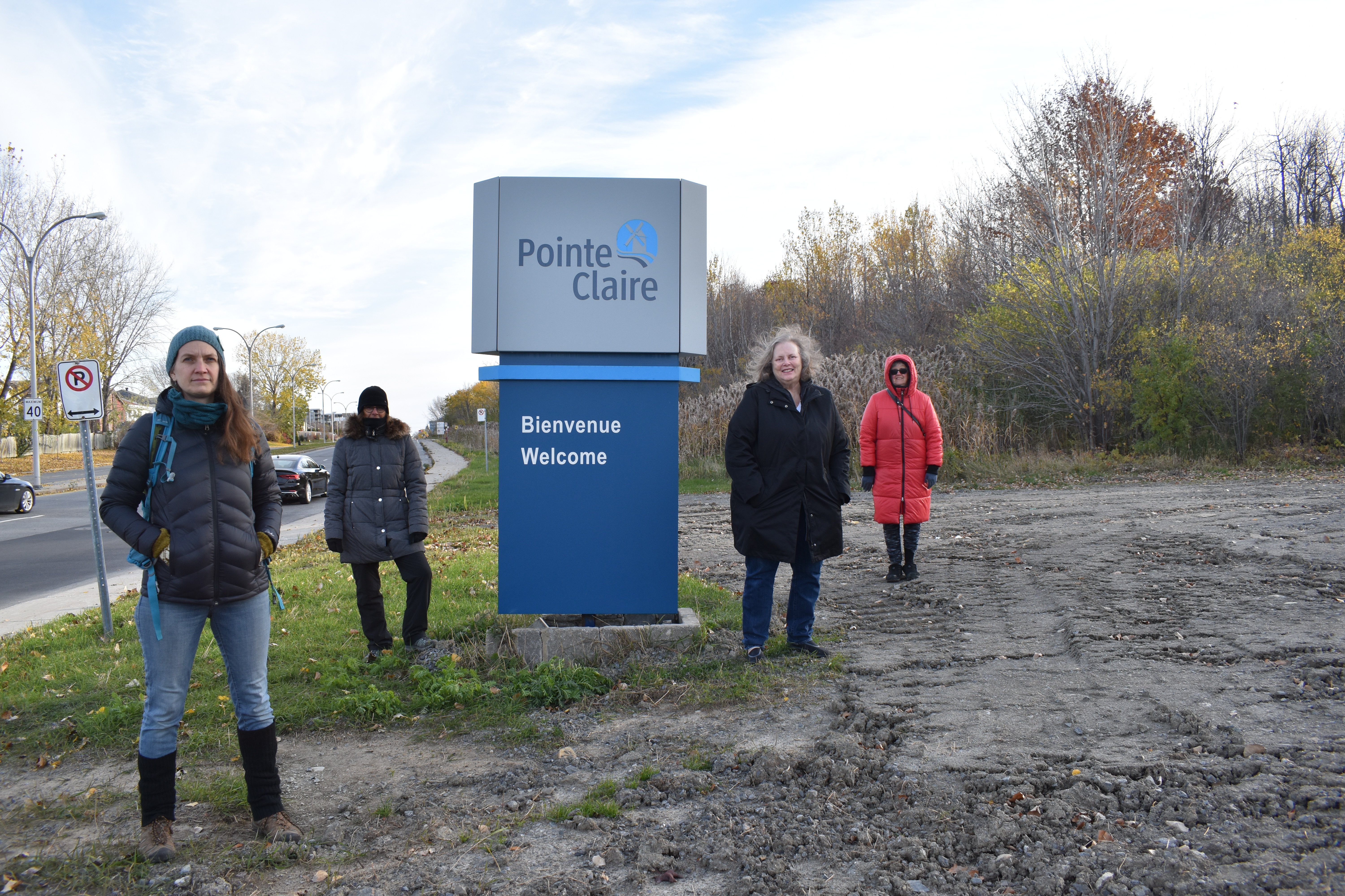 Des citoyens devant une pancarte à la forêt Fariview