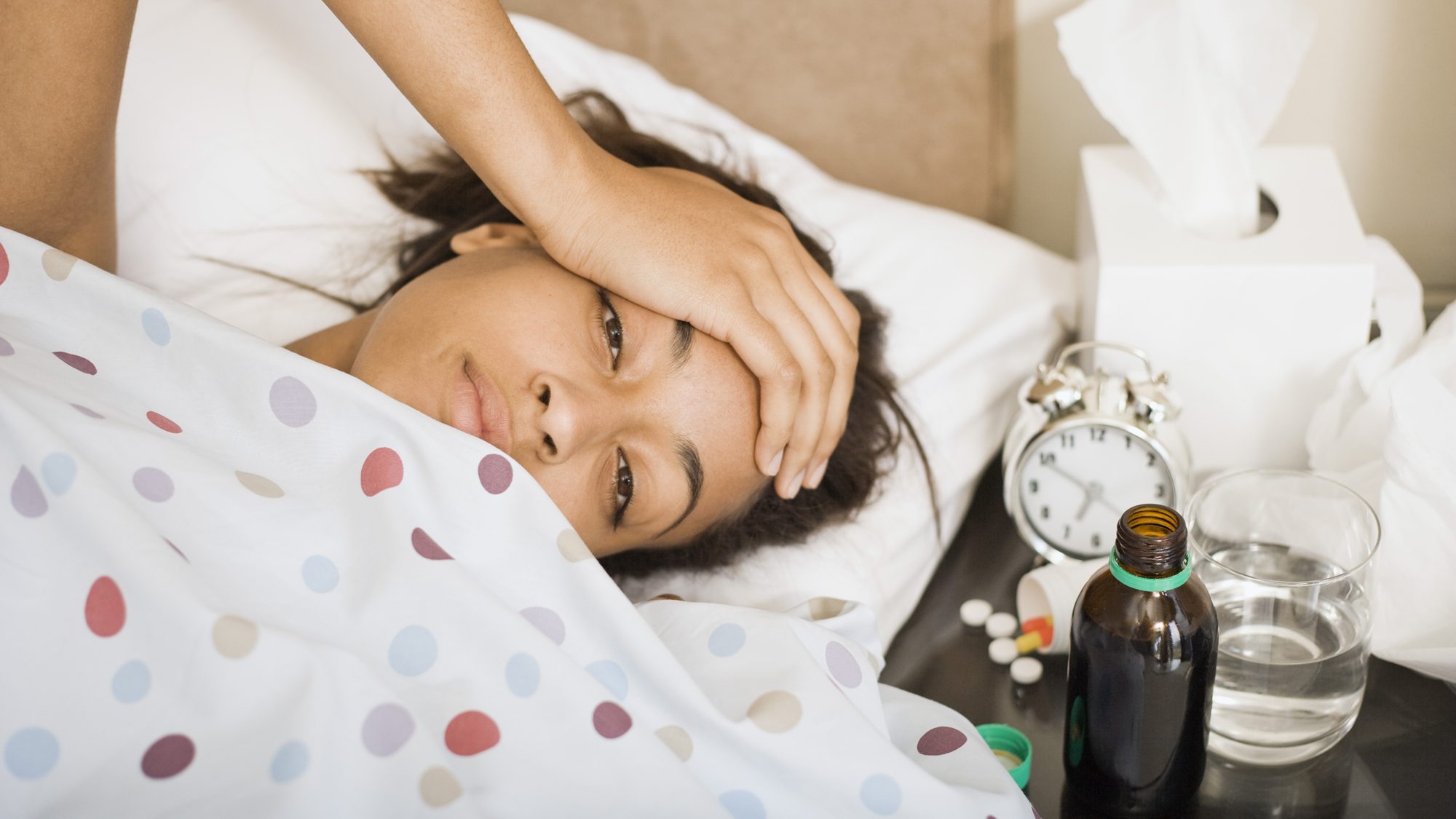 Une femme malade se repose au lit.