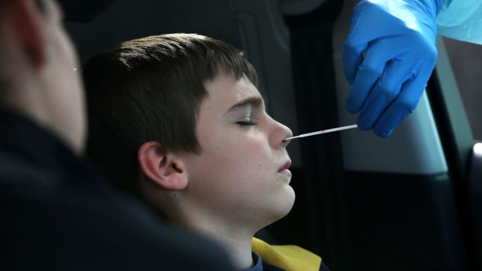 Un jeune garçon subit un test pour la COVID-19.