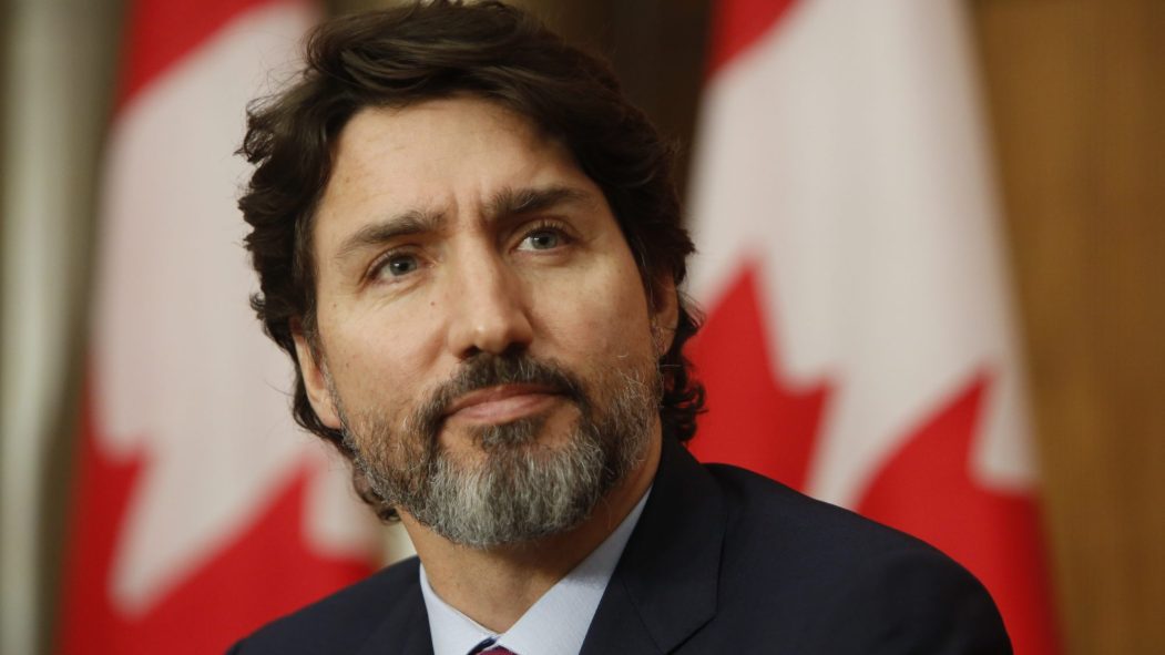 Le premier ministre Justin Trudeau devant des drapeaux du Canada lors d'un point de presse sur la COVID-19.