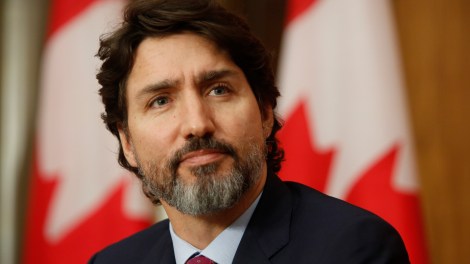 Le premier ministre Justin Trudeau devant des drapeaux du Canada lors d'un point de presse sur la COVID-19.