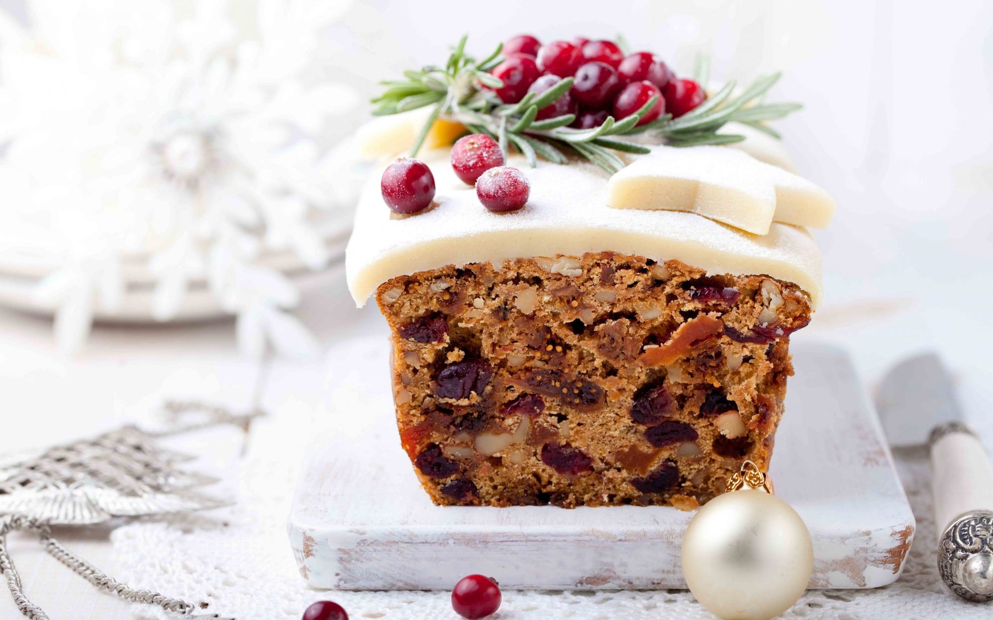 Traditional Christmas pudding Gâteau aux fruits avec du massepain et de canneberge et le décor de romarin sur un décor de fond de Noël