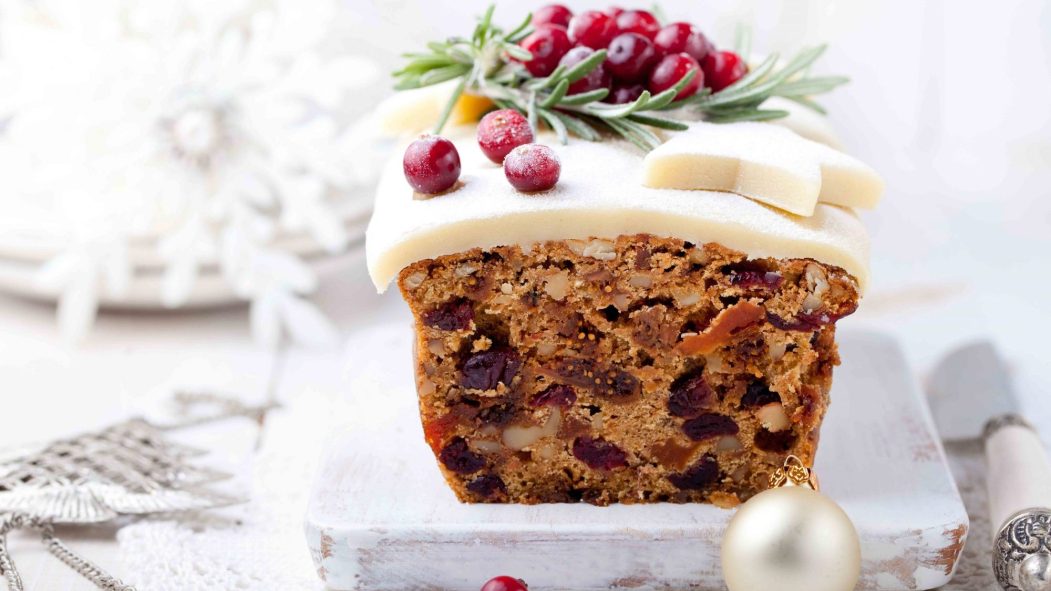 Traditional Christmas pudding Gâteau aux fruits avec du massepain et de canneberge et le décor de romarin sur un décor de fond de Noël