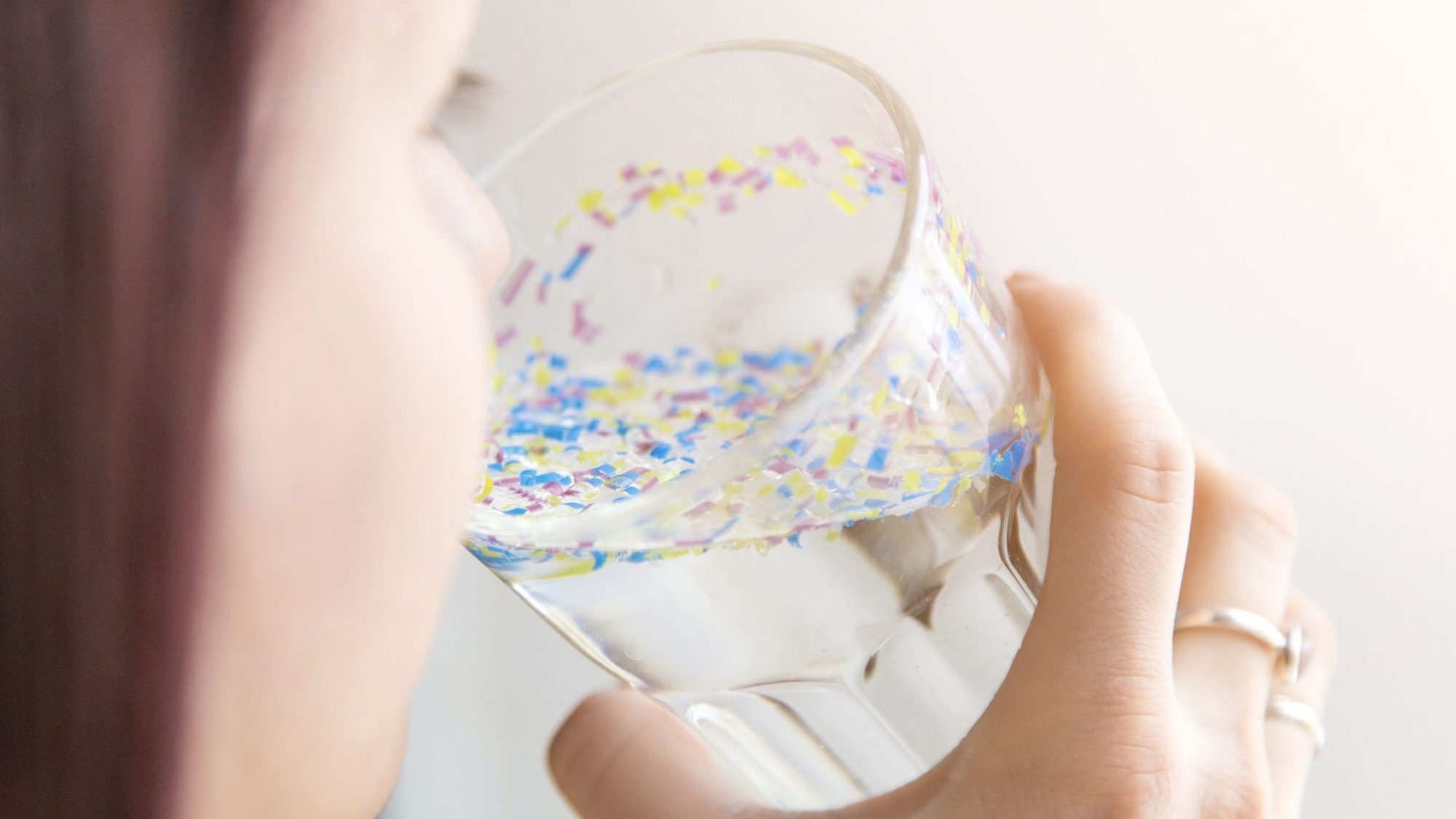 Une fille boit de l'eau polluée aux microplastiques.