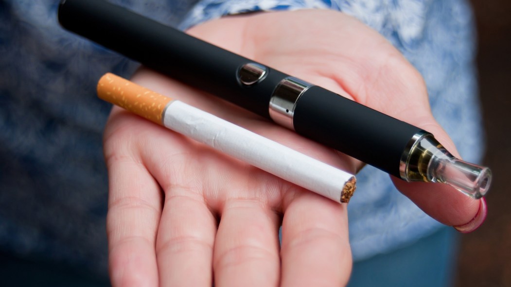 Une cigarette et une vapoteuse dans le creu d'une main