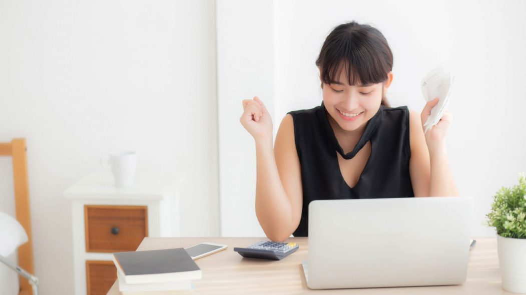 Beautiful young asian woman calculating finance household and writing notebook on desk, girl checking bill and success for saving expenses household with target, debt closure, business concept.