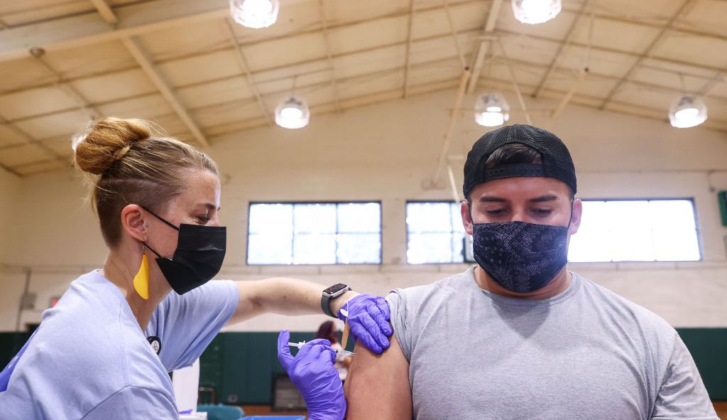 Une femme vaccine un homme.