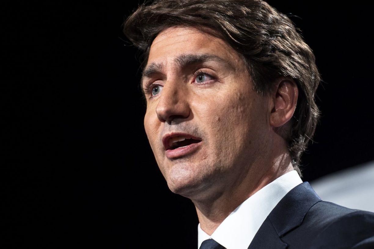 Le premier ministre Justin Trudeau sur fond noir lors d'un discours.