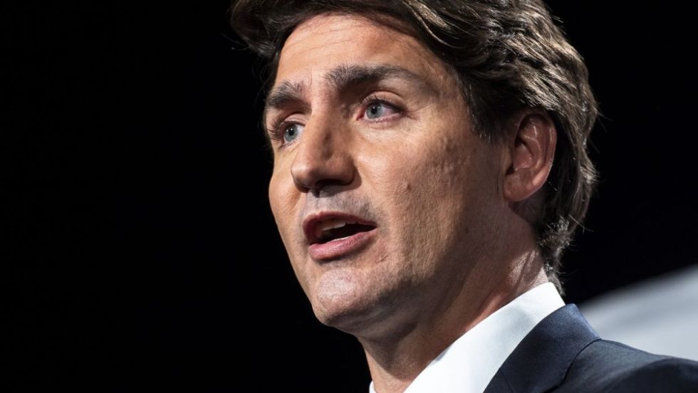 Le premier ministre Justin Trudeau sur fond noir lors d'un discours.