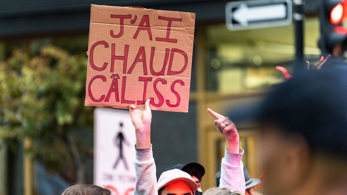 Un manifestant tient une pancarte disant «j'ai chaud câliss» pendant une grève pour le climat.