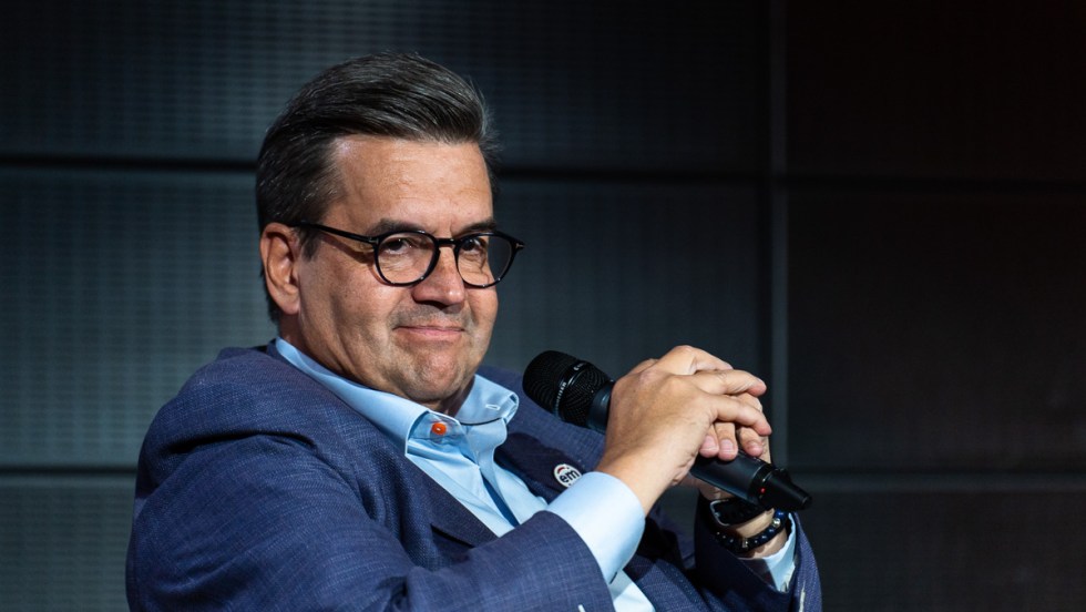 Denis Coderre tient un microphone devant fond noir