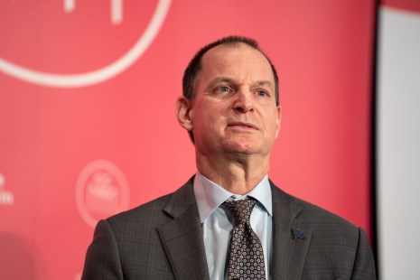 Éric Girard devant une affiche de la Chambre de Commerce du Montréal Métropolitain (CCMM)