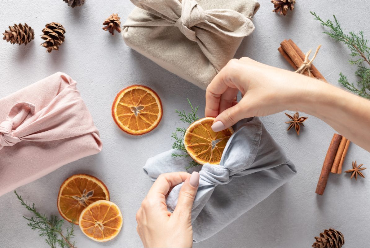 Une femme pratiquant le furoshiki. C'est une technique parfaite pour emballer ses cadeaux sans déchets !