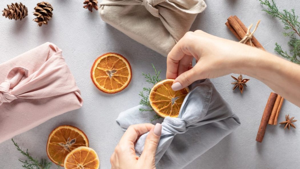 Une femme pratiquant le furoshiki. C'est une technique parfaite pour emballer ses cadeaux sans déchets !