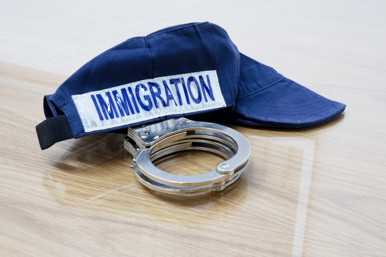 Une casquette d'agent d'immigration et des menottes de policiers