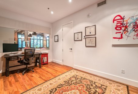 Une chambre à coucher reconvertie en bureau dans un condo style loft urbain à Montréal.