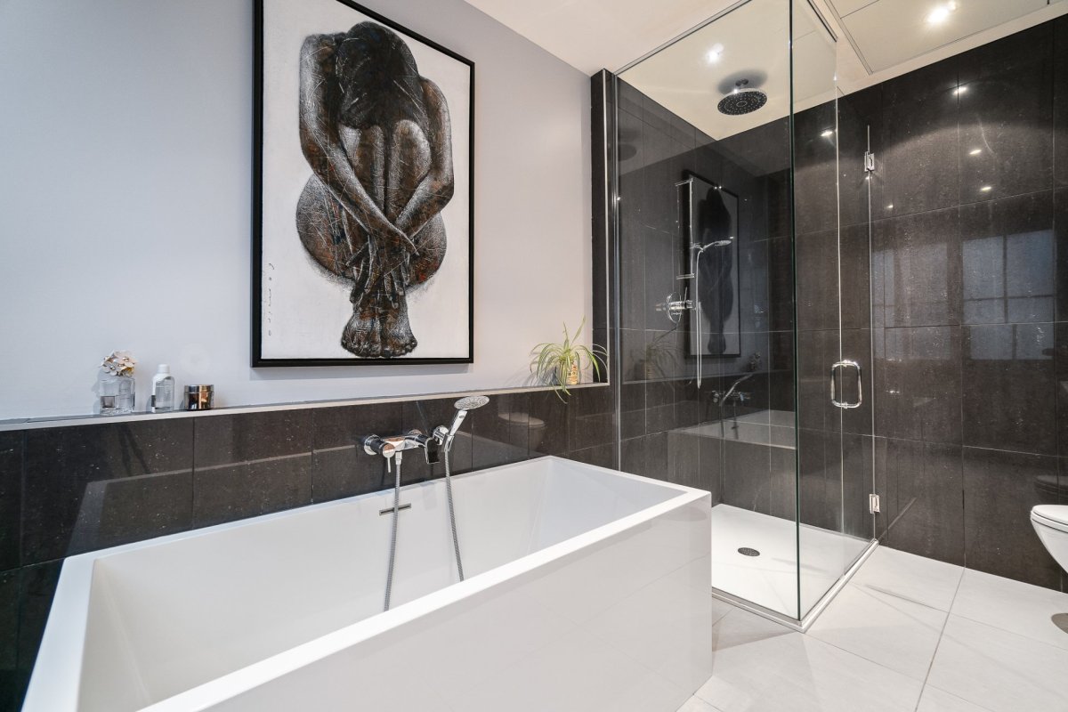 La salle de bain attenante à la chambre principale d'un condo luxueux et style loft urbain, à Ville Marie.