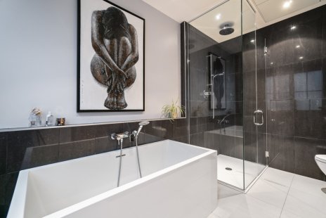 La salle de bain attenante à la chambre principale d'un condo luxueux et style loft urbain, à Ville Marie.