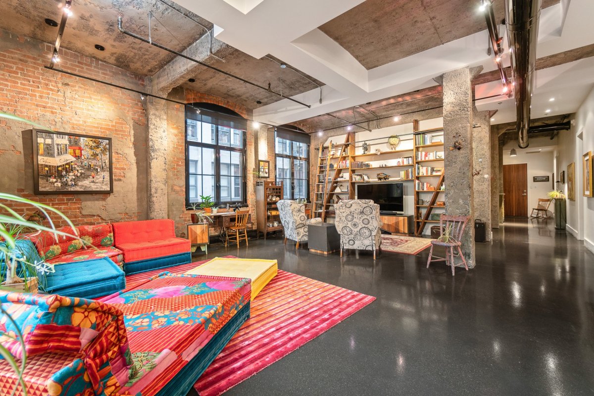 Une vue d'ensemble du salon d'un condo luxueux style loft et urbain, à Ville-Marie.