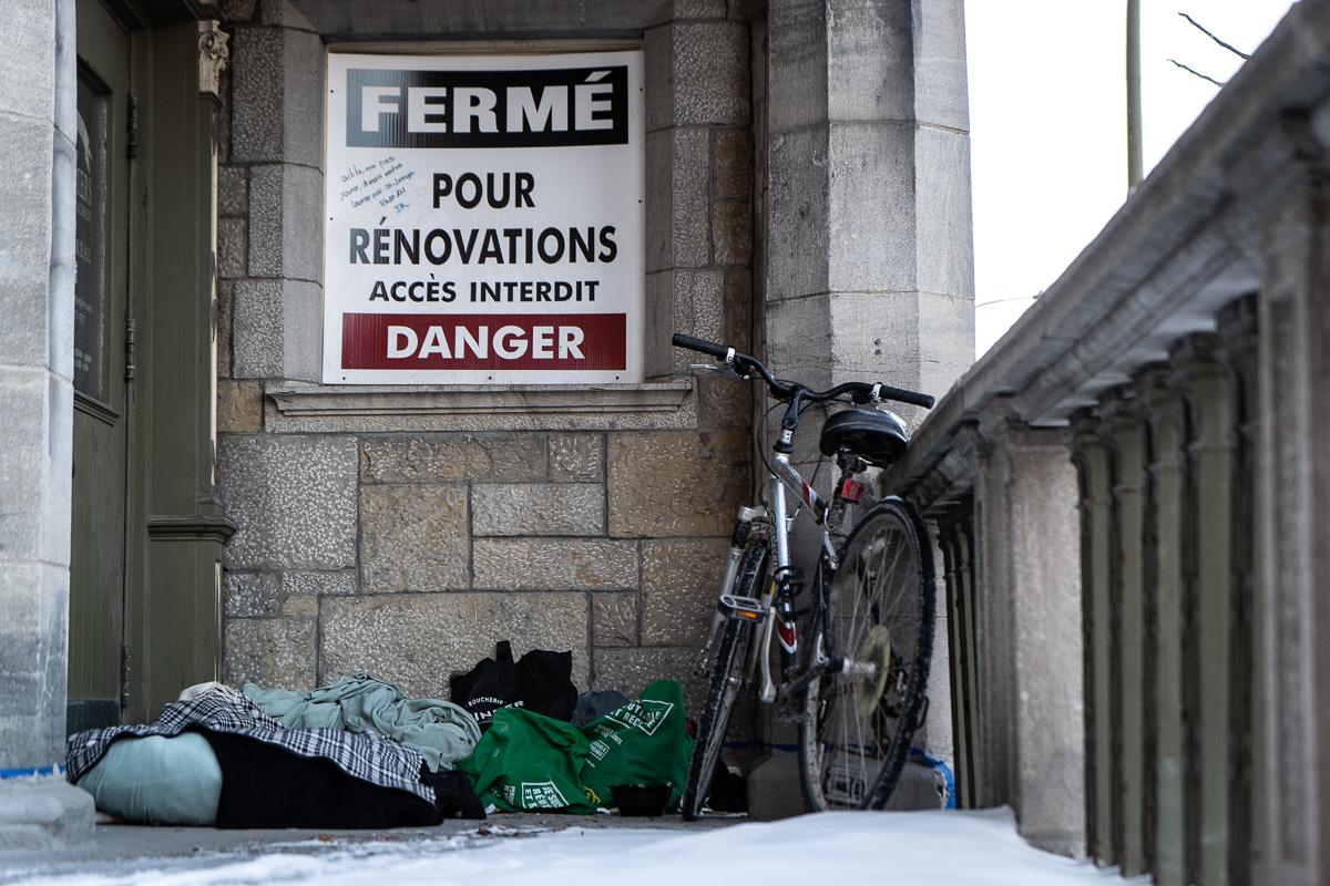 Les objets personnels d'une personne en situation d'itinérance sont cachés dans un escalier à l'abri des regards.