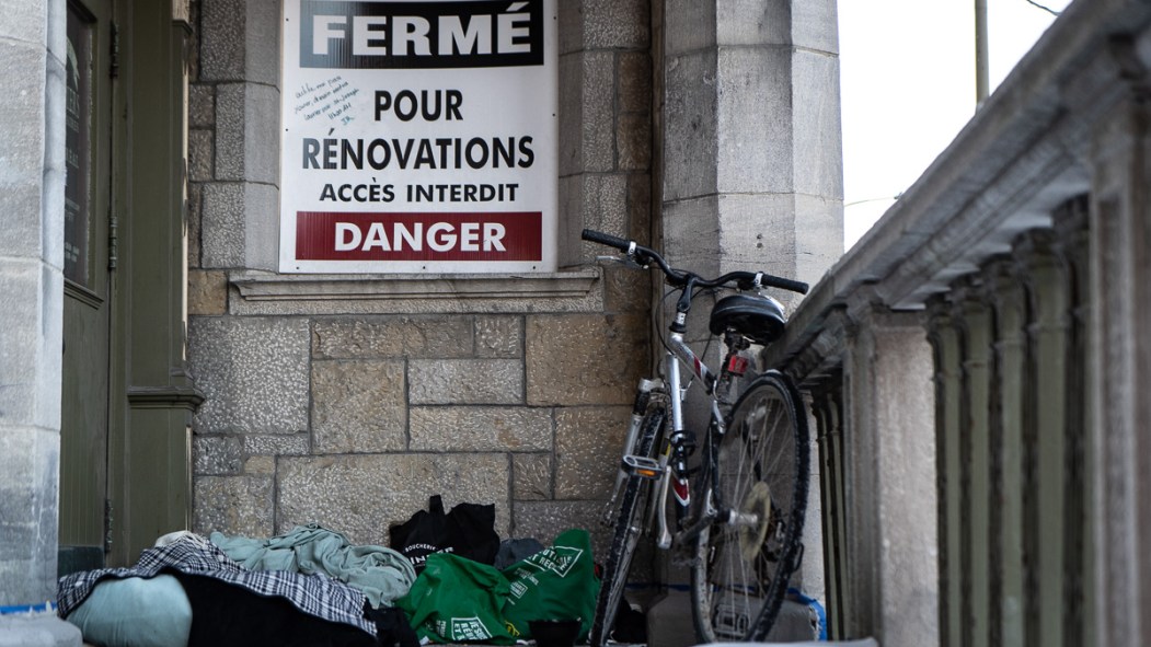 Les objets personnels d'une personne en situation d'itinérance sont cachés dans un escalier à l'abri des regards.