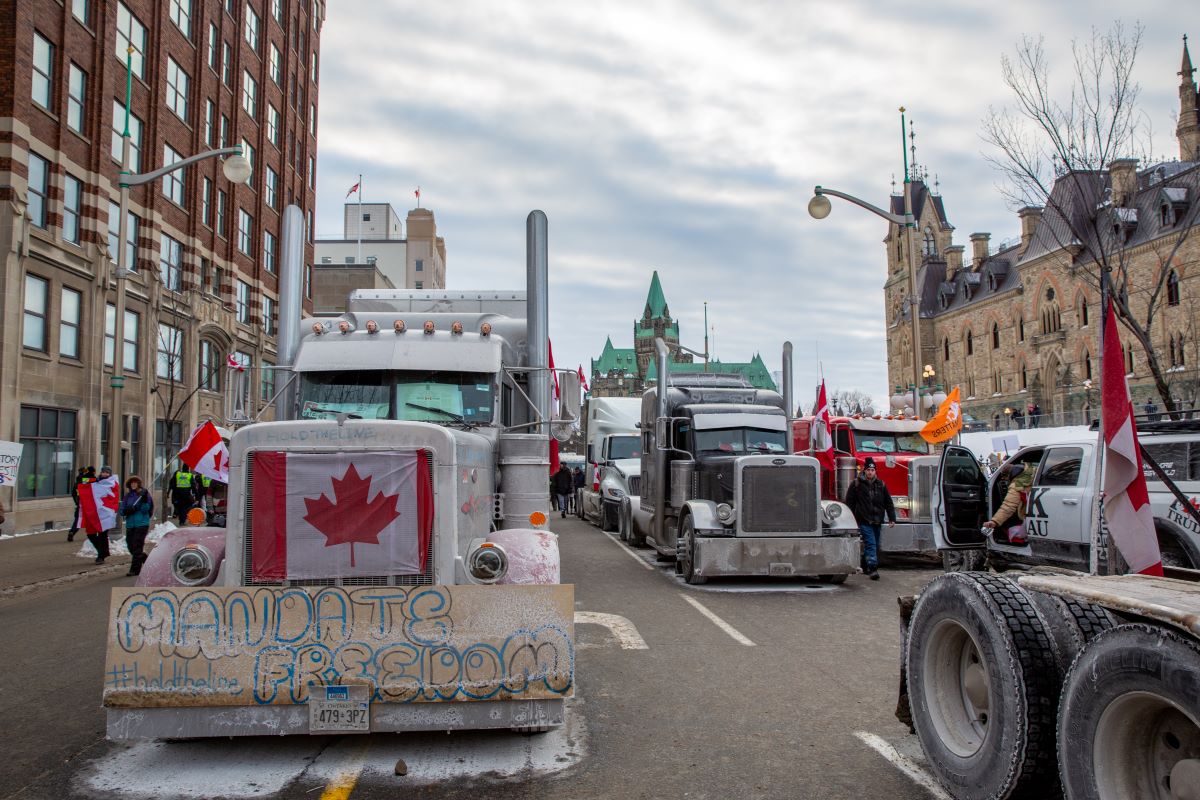 Arrivée de la manifestation de camionneurs nommée convoi de la liberté au centre-ville d'Ottawa. Plusieurs camions affichent des drapeaux canadiens.