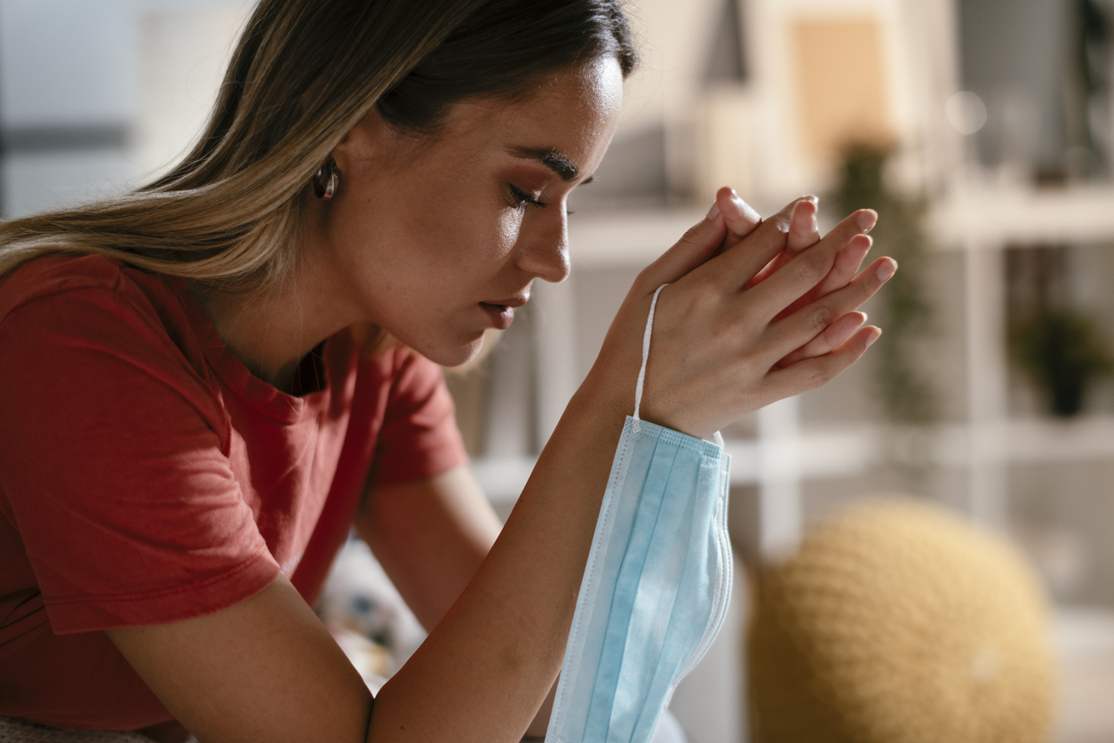 Une jeune femme tenant un masque pendant la pandémie de COVID-19.