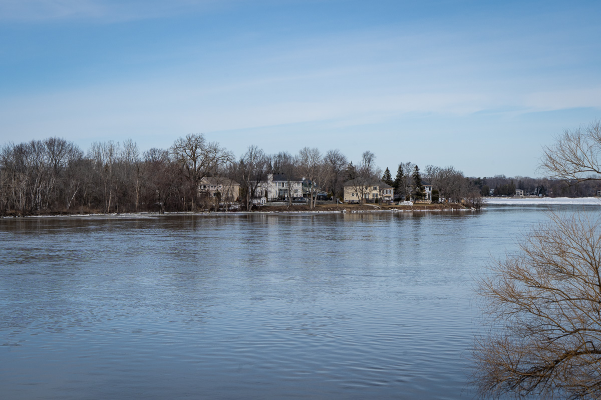 Vue de maisons sur le bord de la rivière des Prairies dans le paysage humanisé de L'Île-Bizard.