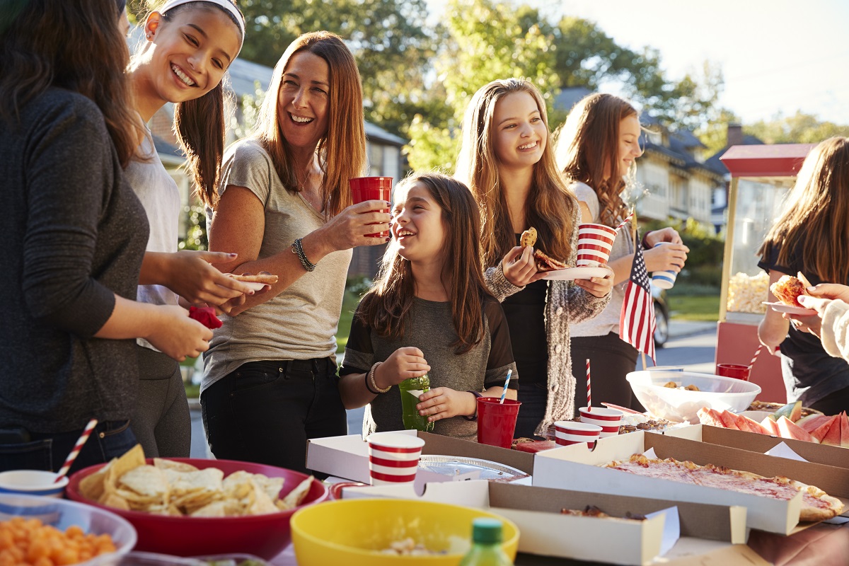 Des adultes et des enfants sont réunis atour d'une table pleine de nourriture