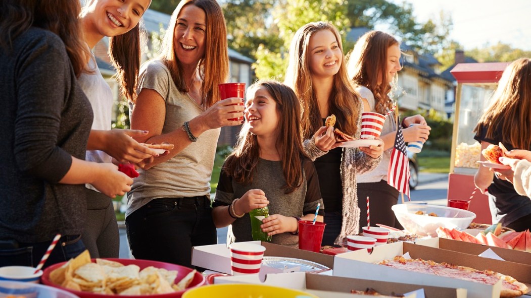 Des adultes et des enfants sont réunis atour d'une table pleine de nourriture