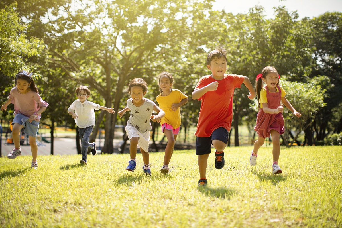 Des enfants courent dans un parc ensoleillé